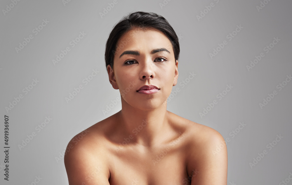 Obraz premium Naturally gorgeous. Studio shot of a young woman with wet hair posing against a gray background.