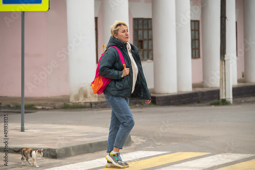 a girl in casual clothes crosses the road through a pedestrian crossing