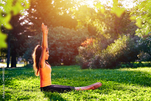 Yoga. Young woman practicing yoga or dancing or stretching in nature at park. Health lifestyle concept