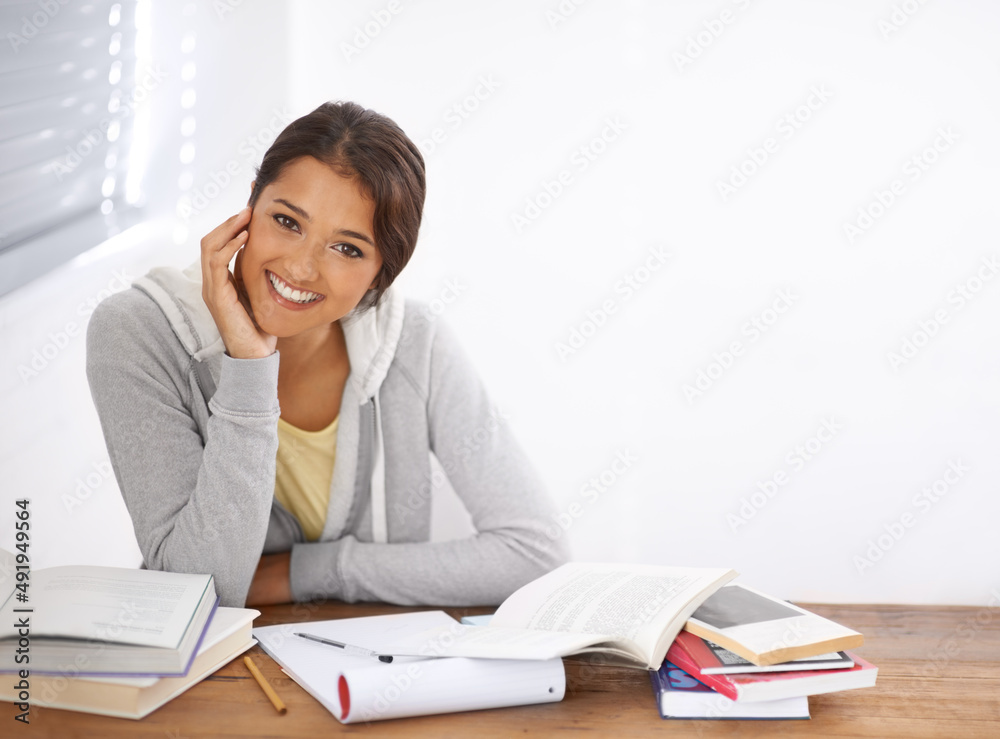 Her studies give her confidence during the exams. A pretty young university student studying for her finals in her dorm room. Her studies give her confidence during the exams. A pretty young university student studying for her finals in her dorm room.