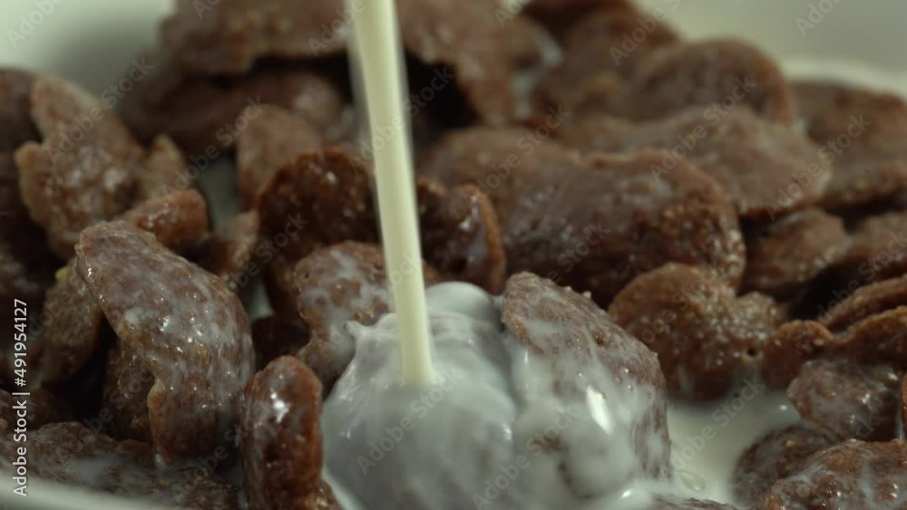 Healthy breakfast pour milk into a white bowl with chocolate cereal. Macro shot. Healthy breakfast pour milk into a white bowl with chocolate cereal. Macro shot.