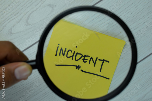 Incident write on sticky notes isolated on Wooden Table.