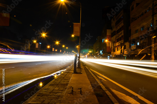 Long exposure of traffic lights and vehicles in the city. Motion blurred landscape of night scene in the city with motion in lights of traffic and city lights. © Lingkon Serao