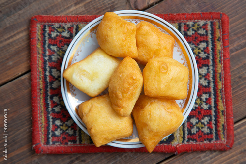 National Kazakh pastries baursaki in a plate on a wooden background