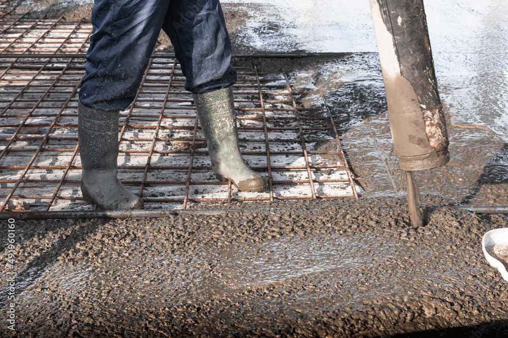 Foto de Builders workers pour concrete floor in industrial