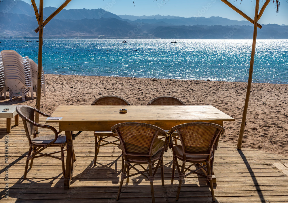 Resting point with wooden floor, table and chairs on sandy beach of the Red Sea, Sinai peninsula, Middle East