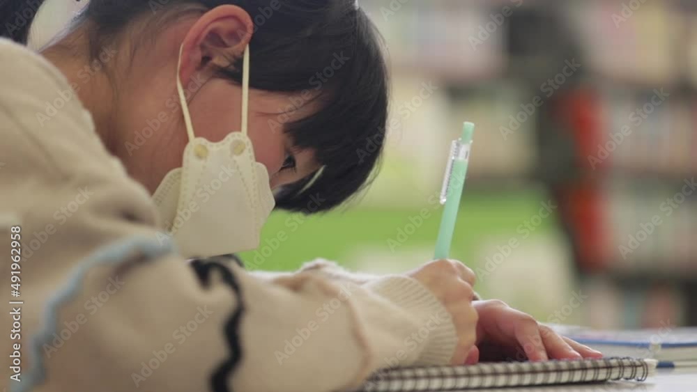 図書館で宿題をしている可愛い小学生の女の子の姿 Stock-video | Adobe Stock