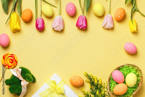 Fototapeta Naklejka Na Ścianę i Meble -  Easter composition on a yellow background. Tulips eggs rabbit gift. Frame with space for text and copy