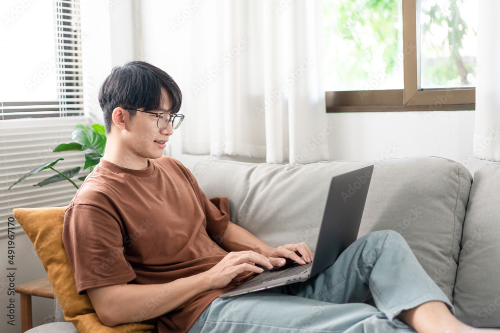 Asian man using laptop for working at his home Asian man using laptop for working at his home