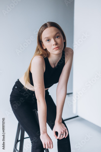Blondie woman portrait. Model photosession on white background. Fashionable girl in black sport clothes 