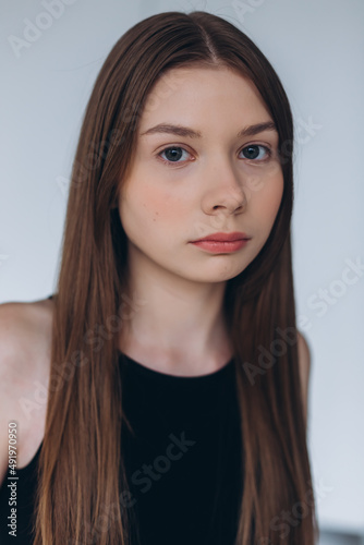 Brunette woman portrait. Model photosession on white background. Fashionable girl in black sport clothes 