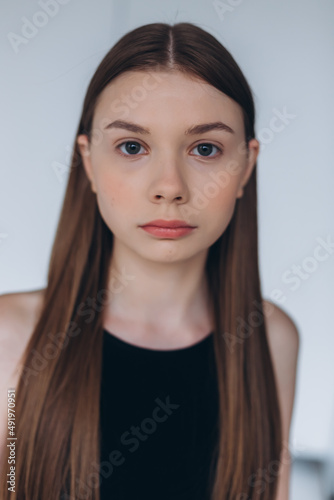 Brunette woman portrait. Model photosession on white background. Fashionable girl in black sport clothes 