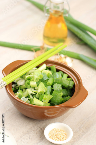 Bowl of chopped spring onions with Oil and Sesame Seed,