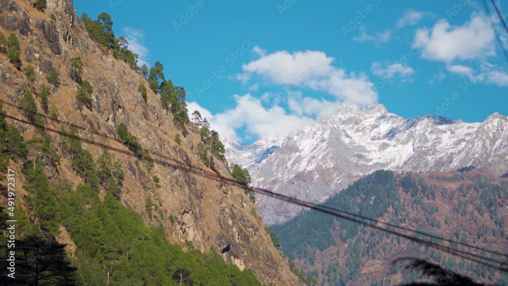 Clouds above the snow covered mountains of the Himalayan mountain range as seen from the Kasol town in Himachal Pradesh, India. Clouds above the snow covered mighty himalayas in the winter. Clouds above the snow covered mountains of the Himalayan mountain range as seen from the Kasol town in Himachal Pradesh, India. Clouds above the snow covered mighty himalayas in the winter.