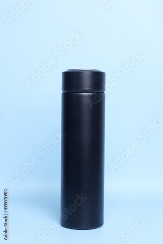 Black thermos or tumbler for mock up isolated on a pastel blue background