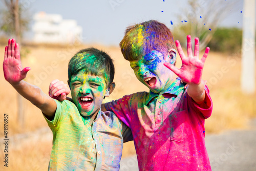 Tableau sur toile cheerful two Indian kids shouting by looking at camera after playing holi - concept of holi festival fun, siblings, and bonding