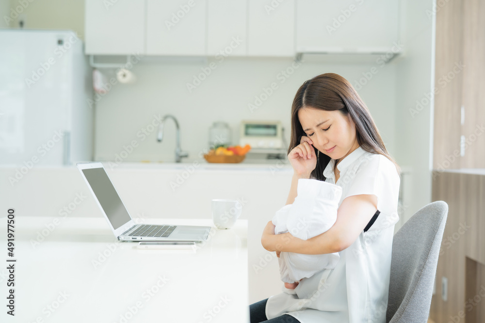 赤ちゃんと仕事で悩む女性
赤ちゃんと仕事で悩む女性