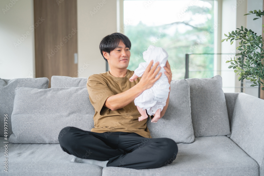 赤ちゃんの面倒を見る男性(笑顔)
赤ちゃんの面倒を見る男性(笑顔)