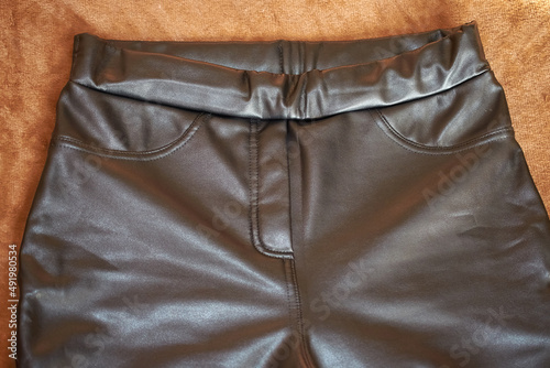 Upper part of black leather pants, front view