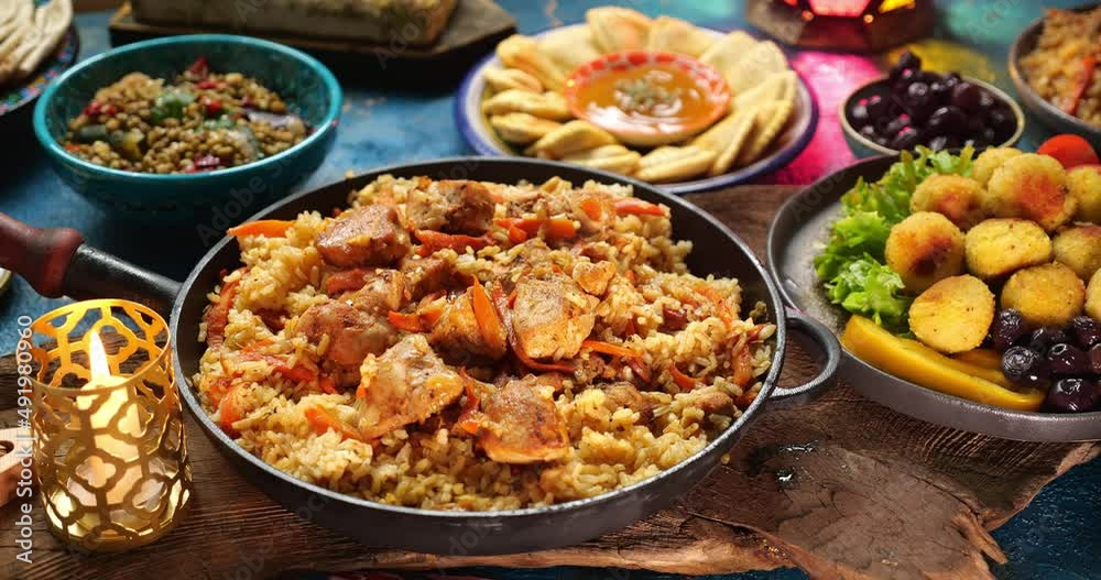 Traditional food of Ramadan. Pilaf plov or pilau is a rice dish, adding spices and meat. Eid al-Fitr Table Setting, halal meals Traditional food of Ramadan. Pilaf plov or pilau is a rice dish, adding spices and meat. Eid al-Fitr Table Setting, halal meals