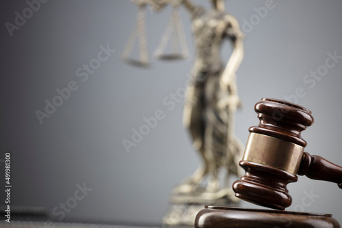 Law and justice concept. War crimes. Gavel, Themis sculpture and scale in lawyers office. Gray background. photo