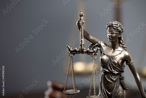 Law and justice concept. War crimes. Gavel, Themis sculpture and scale in lawyers office. Gray background. photo
