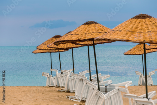 Beach straw umbrella on sunset by the sea  blue hour. amazing waves and clouds. 