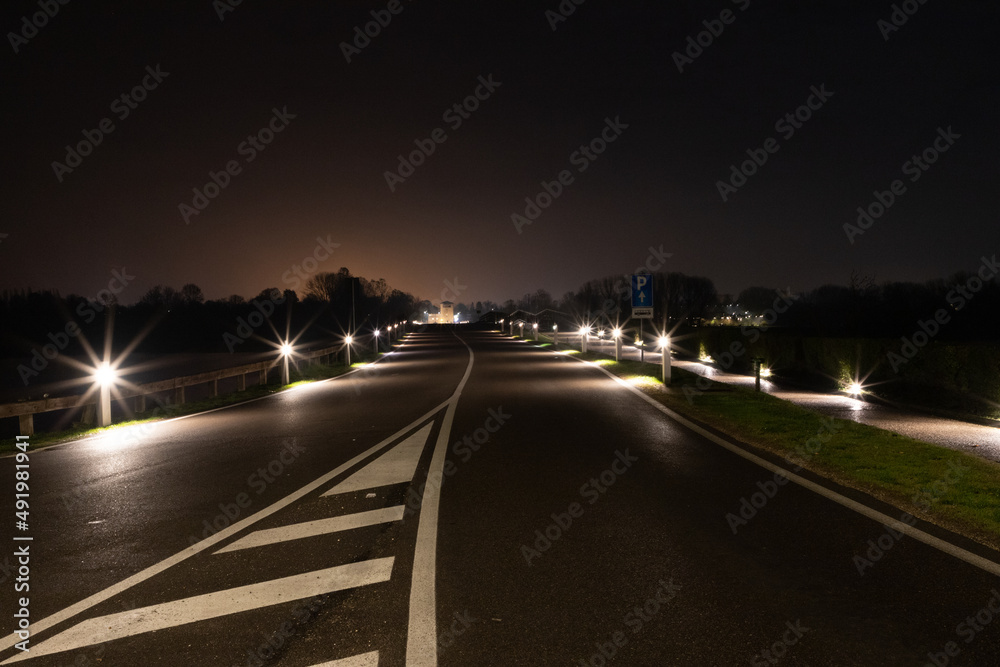 Street illuminated at night on the lakes near the center of Mantua