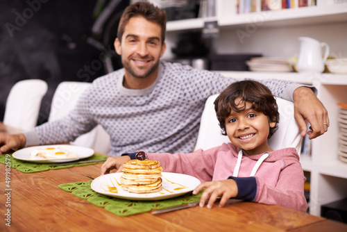 Daddy makes the best pancakes. Portrait of a father and son having breakfast together.