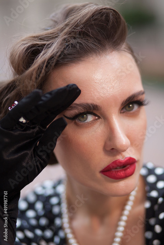 Portrait of beautiful woman in retro style with hairdress and great makeup photo