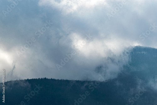 Gęste chmury nad górskim zboczem, mgła w lesie. © Grzegorz