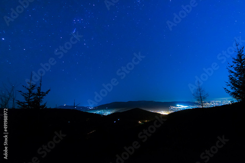 Konstelacje gwiazd na nocnym niebie, w dolinie miasteczko.
