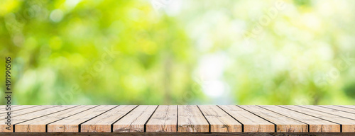 Empty wooden table with garden bokeh for a catering or food background with a country outdoor theme,Template mock up for display of product