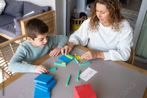 Mother teaching her son math with base 10 method at home