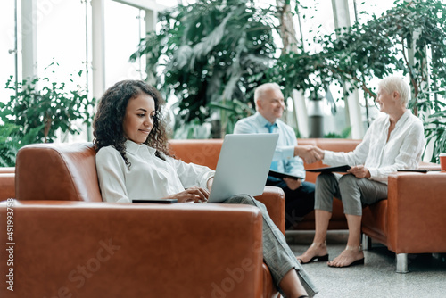 Obraz na płótnie young businesswoman using a laptop while sitting in the lobby of a business center. w salonie