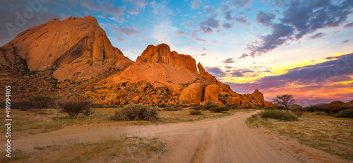 Granite rocks of Spitzkoppe with yellow and blue clouds at sunset