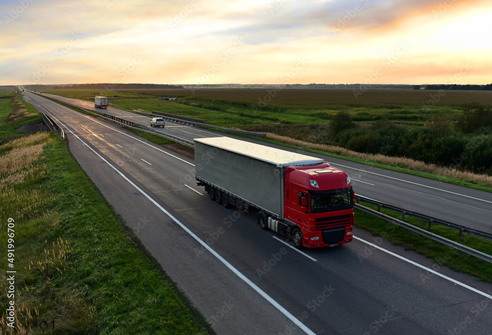 Freight truck. Truck with semi-trailer driving along highway. Goods delivery by roads. Services and Transport logistics. Lorry on delivery. Long Self-driving lorries. Shipping freight logistics.