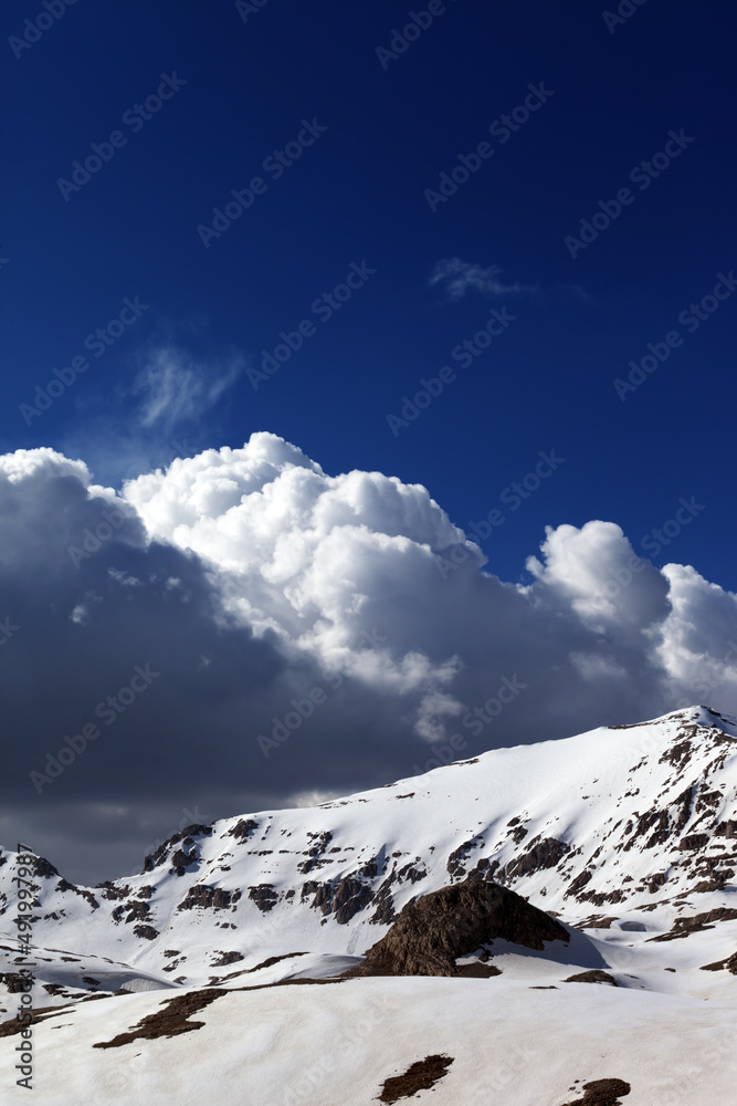 Snowy mountains and blue sky with clouds