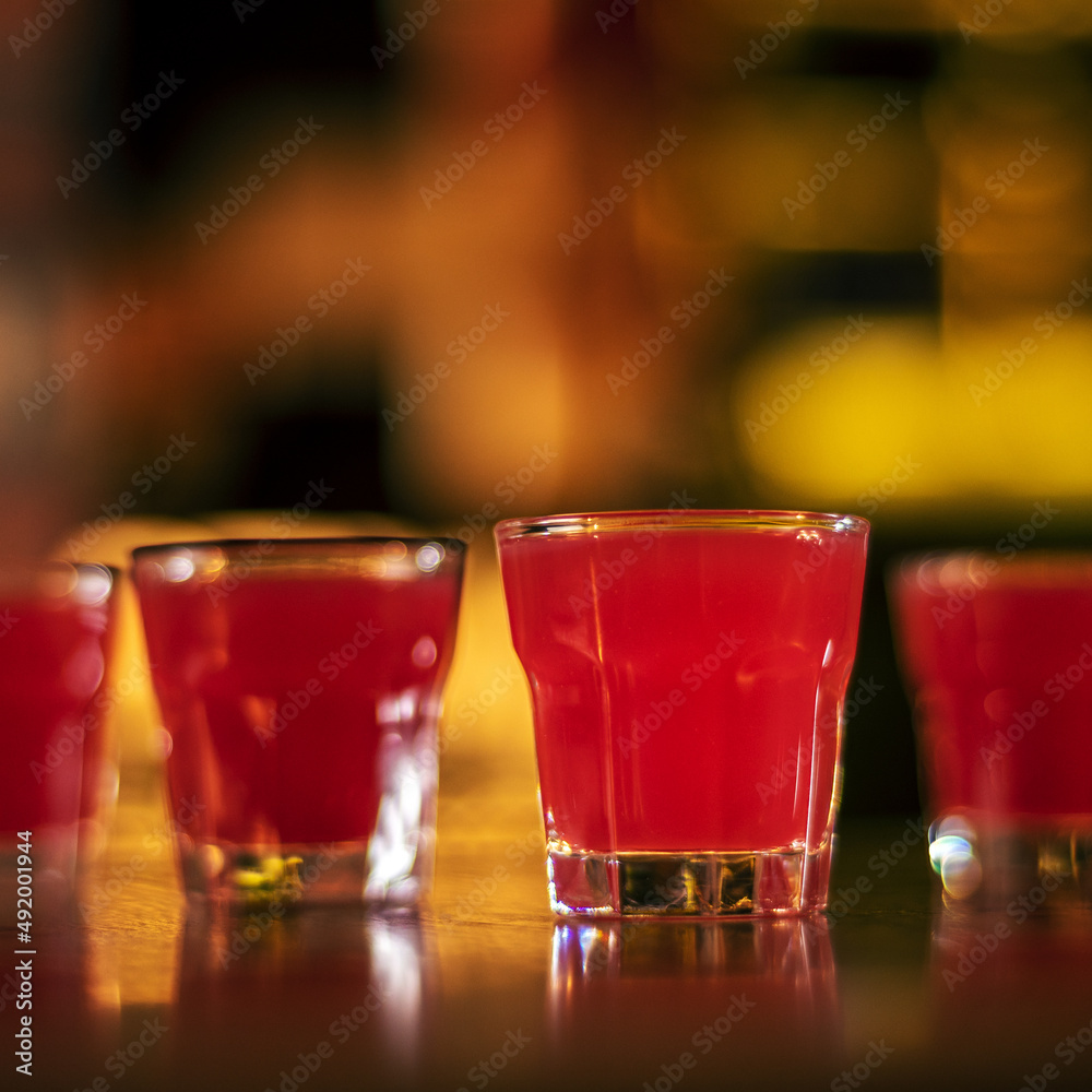 glass of alcohol shots on blurred background square glass of alcohol shots on blurred background square