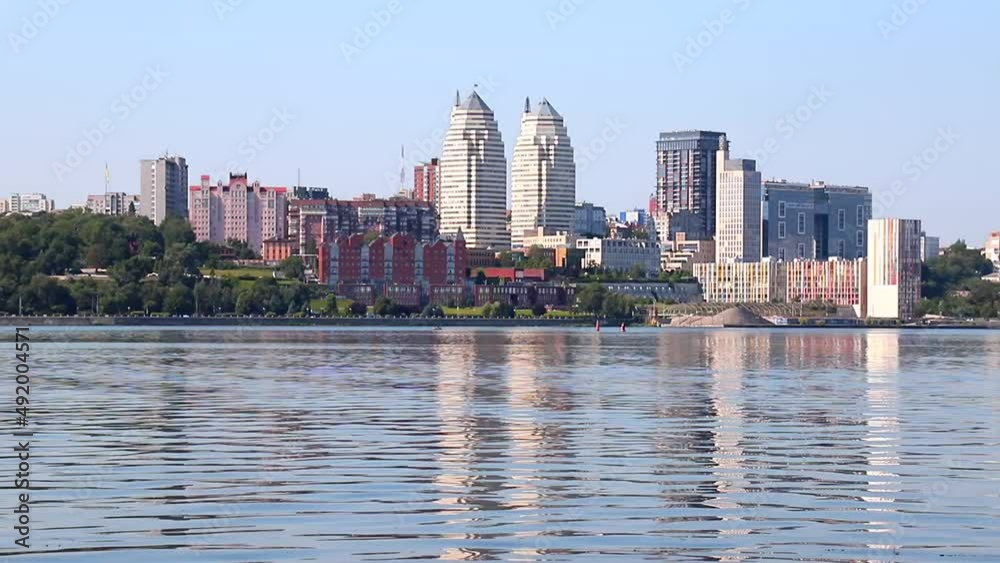 Big city on banks of wide river. Beautiful modern towers, buildings, skyscrapers are reflected in water in summer,Spring. Ukrainian city Dnipro, Dnepropetrovsk, Ukraine Big city on banks of wide river. Beautiful modern towers, buildings, skyscrapers are reflected in water in summer,Spring. Ukrainian city Dnipro, Dnepropetrovsk, Ukraine