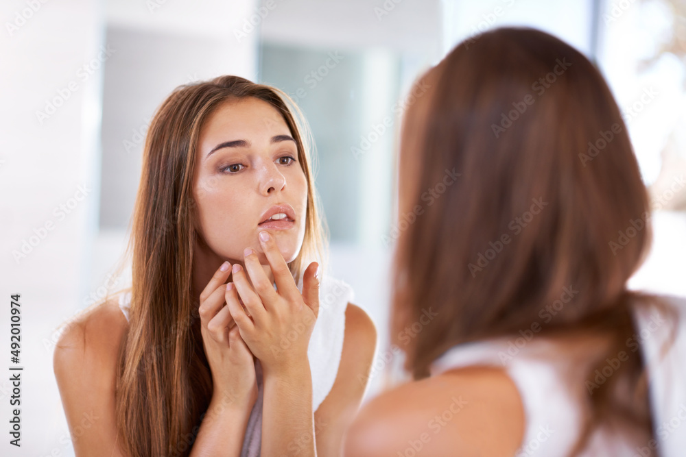 Judging beauty. Over the shoulder shot of an attractive young woman looking at her reflection in a mirror. Judging beauty. Over the shoulder shot of an attractive young woman looking at her reflection in a mirror.