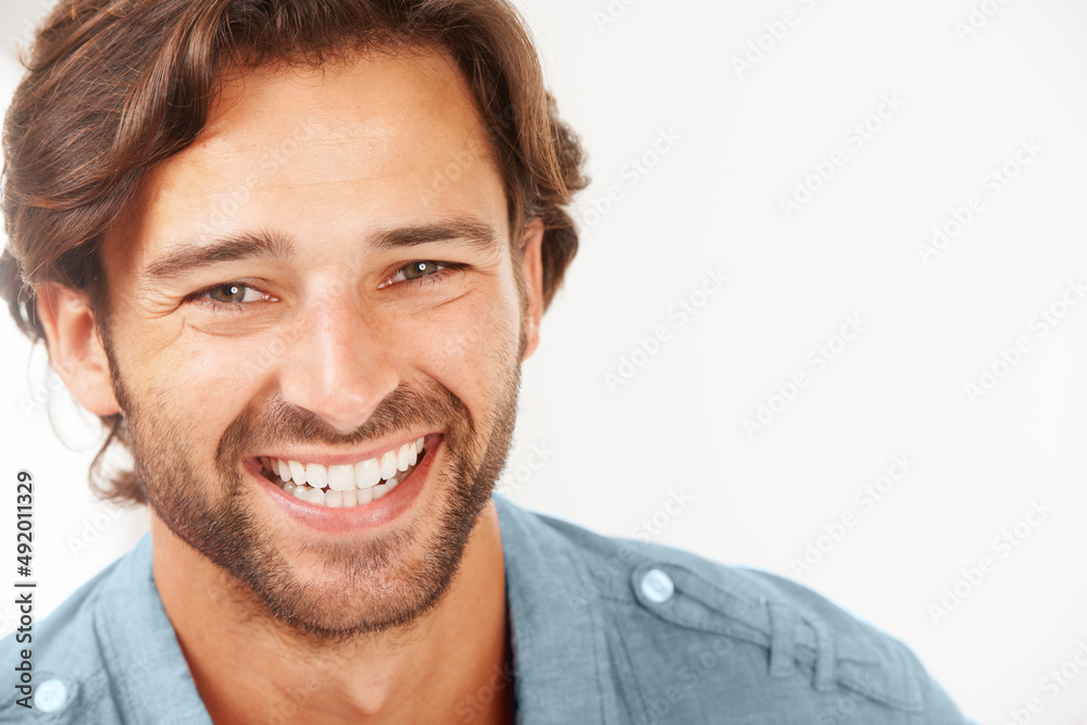 Hes full of positivity. A handsome man smiling against a white background. Hes full of positivity. A handsome man smiling against a white background.