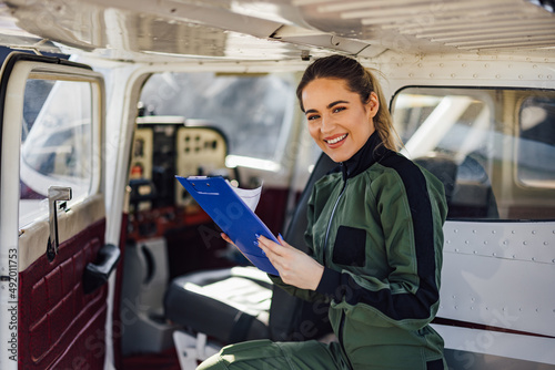 Portrait of a joyful female pilot, looking at the camera, while