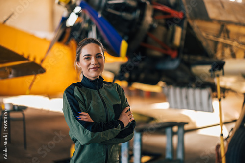 Принти на полотні Proud female airforce pilot, posing for the camera in front of a plane