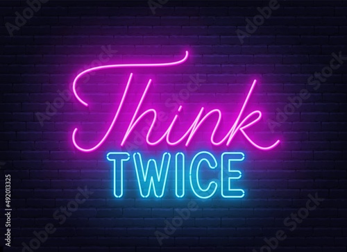 Think Twice neon lettering on brick wall background. photo