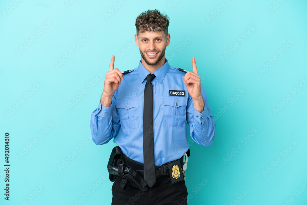 Young police blonde man isolated white on blue background pointing up a great idea Young police blonde man isolated white on blue background pointing up a great idea