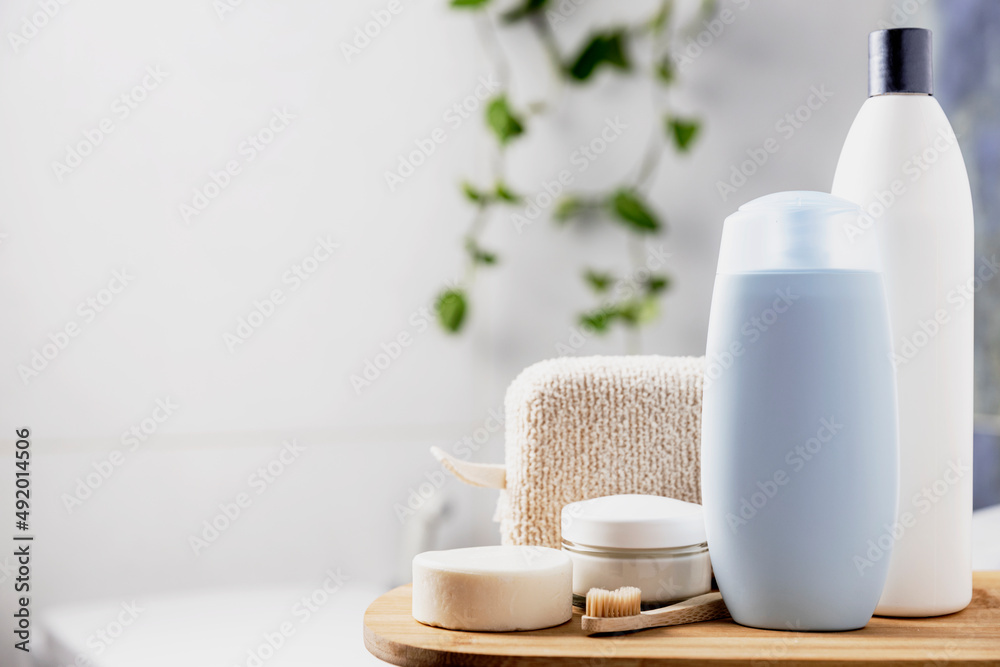 Preparation for hotel spa treatment or home bath procedure. Bathroom with accessories and cosmetics. Shampoo, shower gel, hair conditioner, washcloth, soap, tooth brush, cream glass bottle, white soap