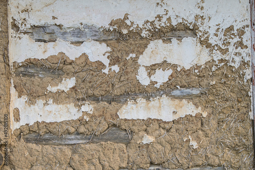 Sunja, Croatia, April 20,2021 : Facade of mud and straw on old wooden house. photo