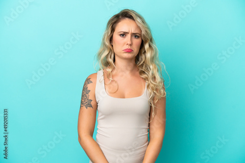 Young Brazilian woman isolated on blue background with sad expression