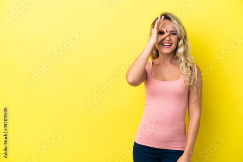 Young Brazilian woman isolated on yellow background showing ok sign with fingers